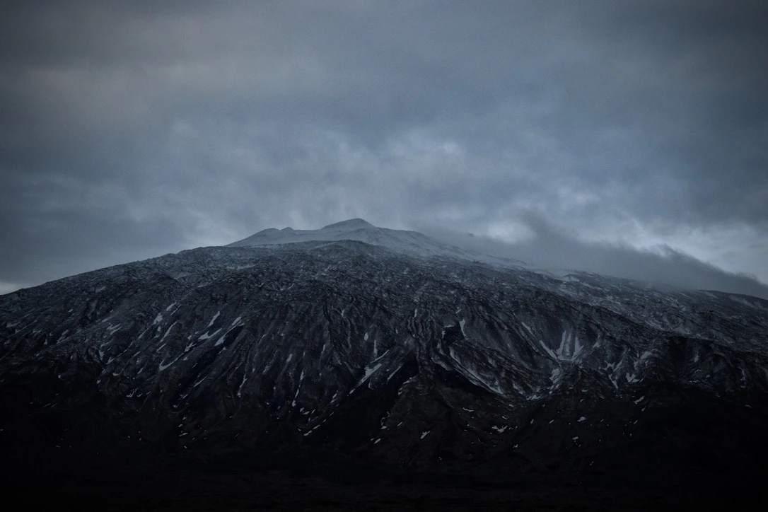 Snow-dusted mountain beneath low clouds